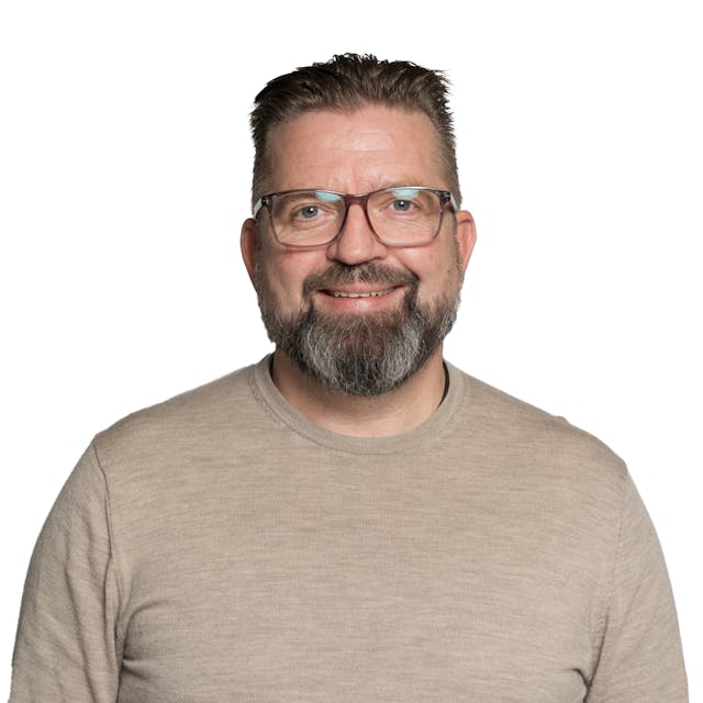 Profilbilde av smilende voksen mann med briller og skjegg
