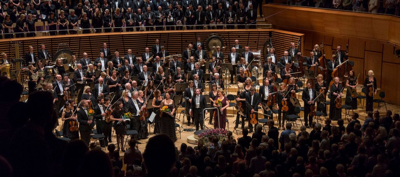 Bilde av et symfoniorkester med mange musikanter som holder instrumenter