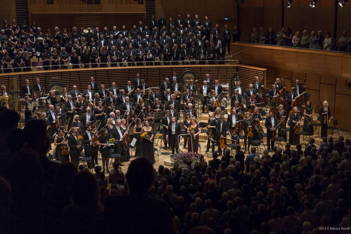 Bilde av et symfoniorkester med mange musikanter som holder instrumenter